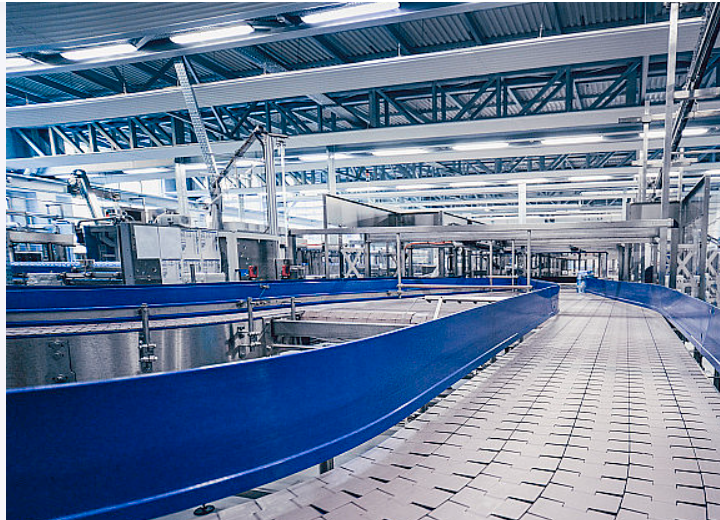 现代化绿色工业园区概念图，太阳能板和风力发电机点缀其间，体现可持续发展理念的未来工厂设计